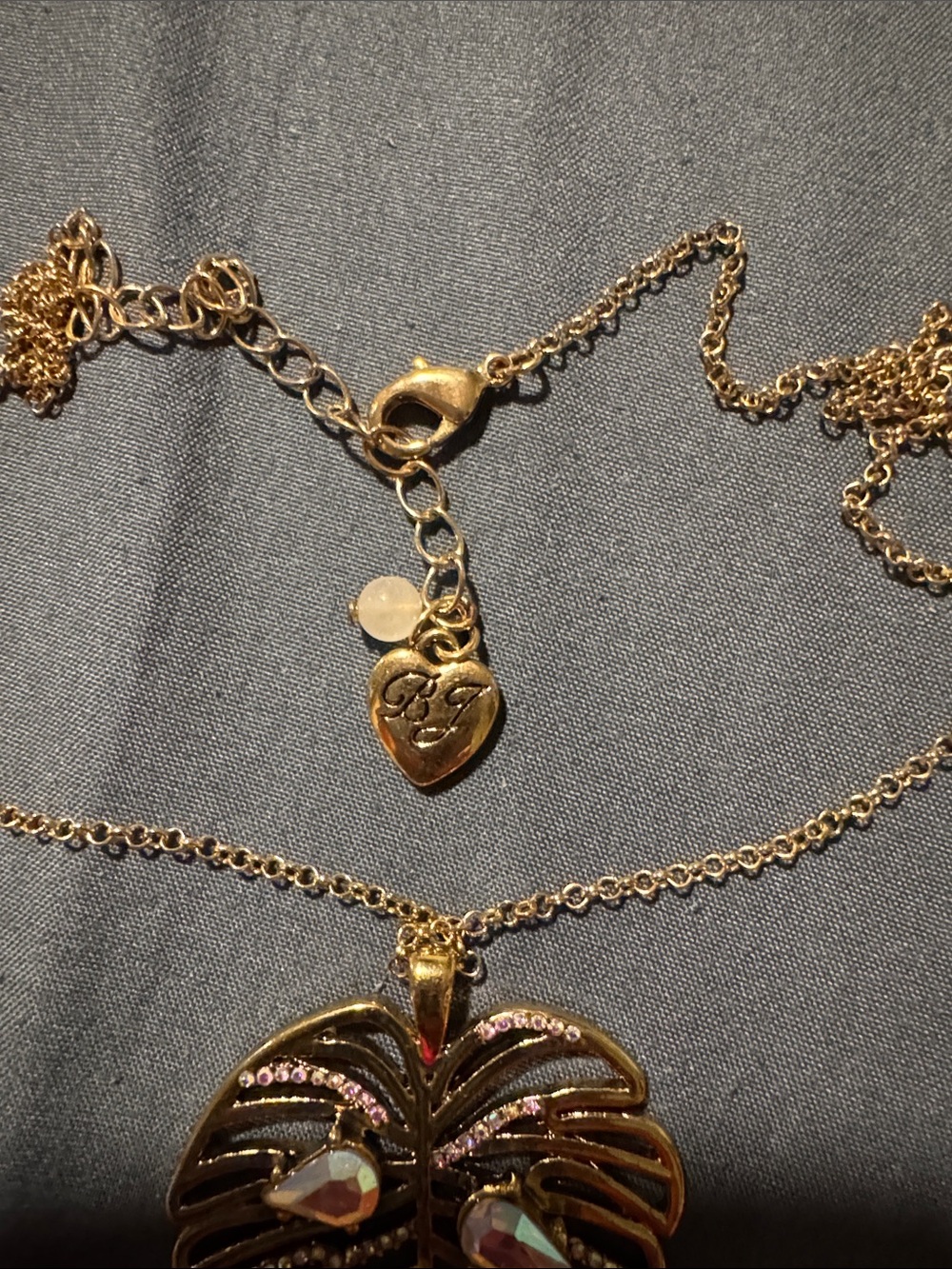 Betsey Johnson Gold Monstera Leaf Necklace with Iridescent Pink-Purple Teardrops - Picture 2 of 3